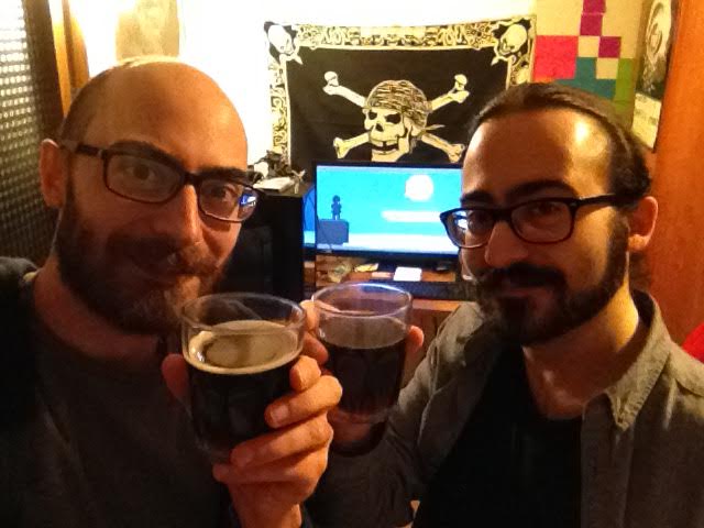 Photo of Leafdog Games Brothers while drinking to celebrate the release of the game, with screen behind showing the game intro